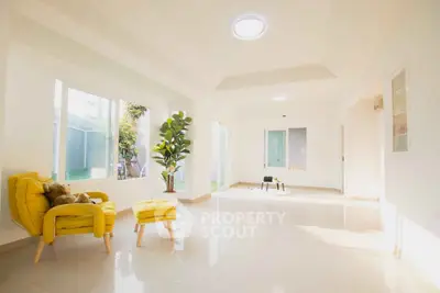 Bright and spacious living room with modern yellow armchair and natural light