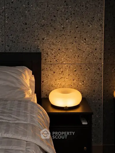 Cozy bedroom with modern bedside lamp and textured wall