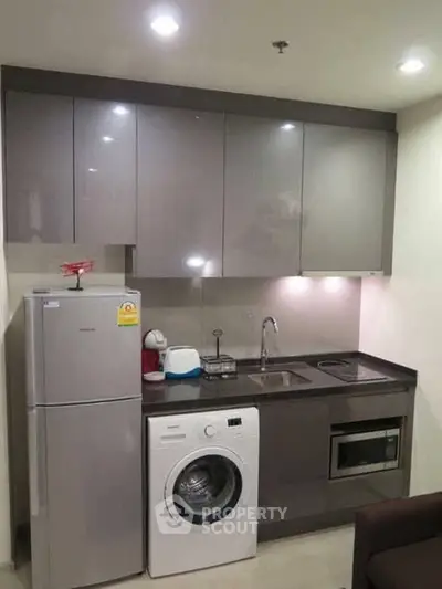 Modern compact kitchen with washing machine and sleek cabinetry