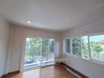 Bright room with large windows and balcony overlooking greenery