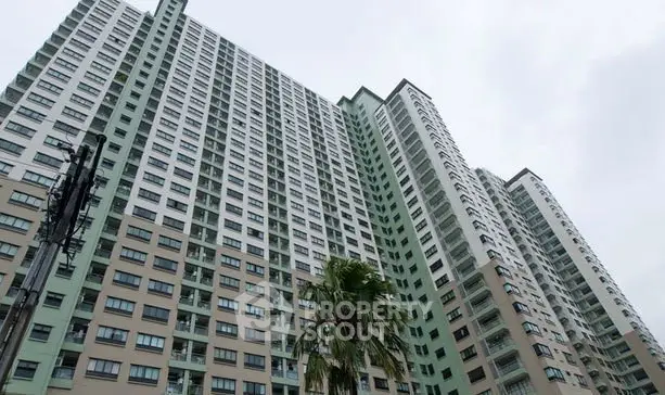 Modern high-rise residential building with palm tree in foreground