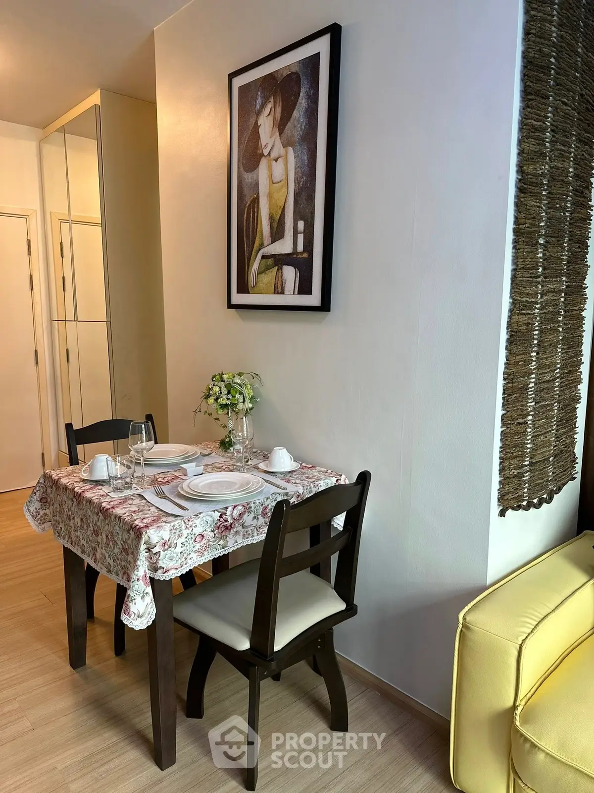 Cozy dining nook with elegant decor and stylish artwork in modern apartment.