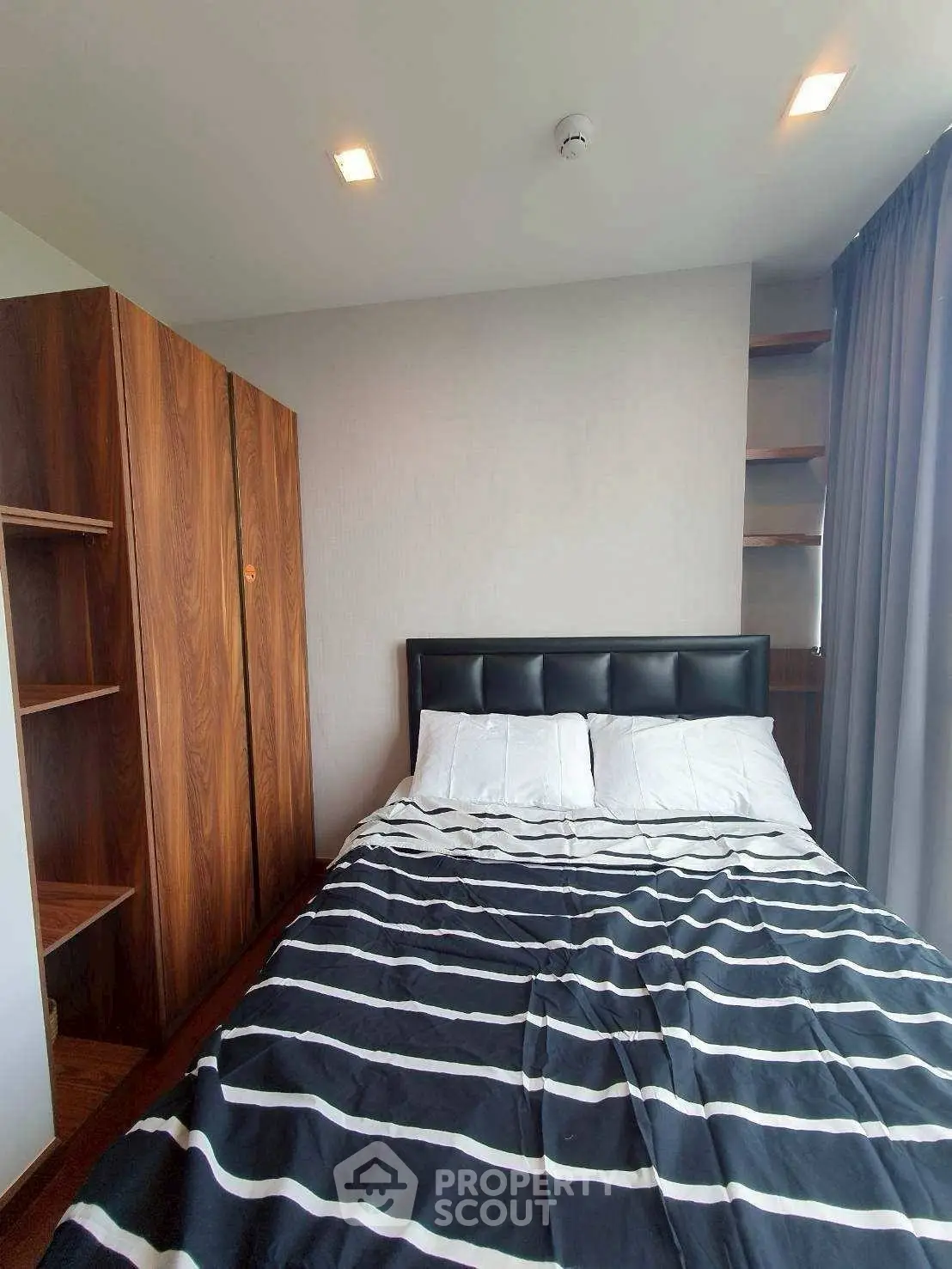 Modern bedroom with stylish wooden wardrobe and cozy bed in a bright apartment.