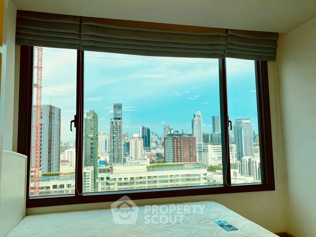Stunning city view from a modern high-rise bedroom window, showcasing urban skyline.