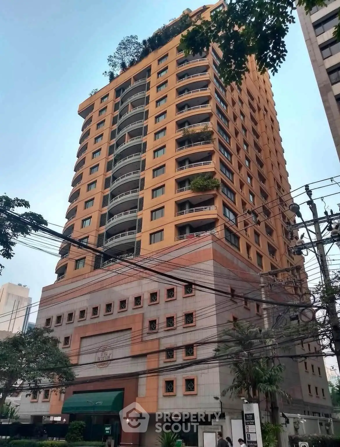 Stunning high-rise building with lush rooftop garden and modern architecture in urban setting.
