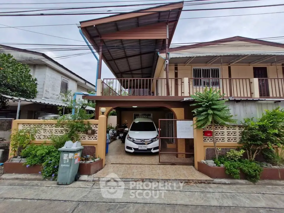 Charming suburban house with carport and lush greenery in a quiet neighborhood.