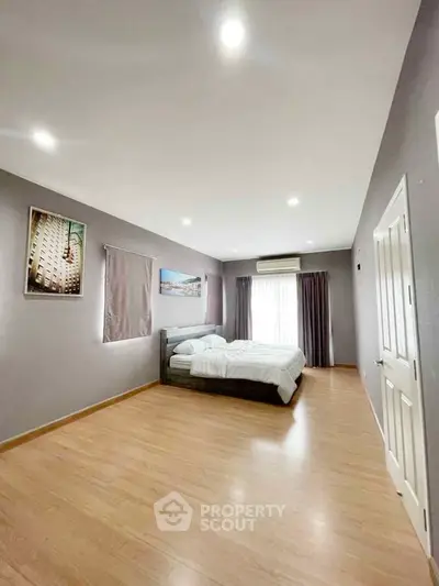 Spacious bedroom with modern decor and ample natural light