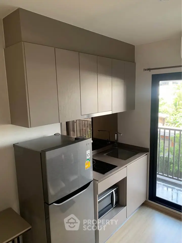Modern kitchen with sleek cabinetry and stainless steel appliances in a bright apartment.