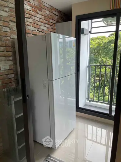 Modern kitchen with sleek refrigerator and balcony view, perfect for urban living.