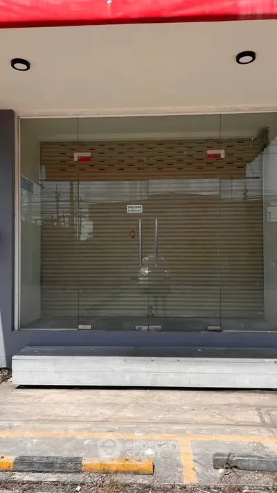 Modern commercial property with glass facade and secure entrance, ideal for retail or office space.