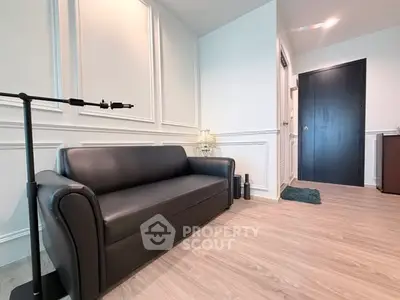 Modern living room with sleek black sofa and elegant wall paneling