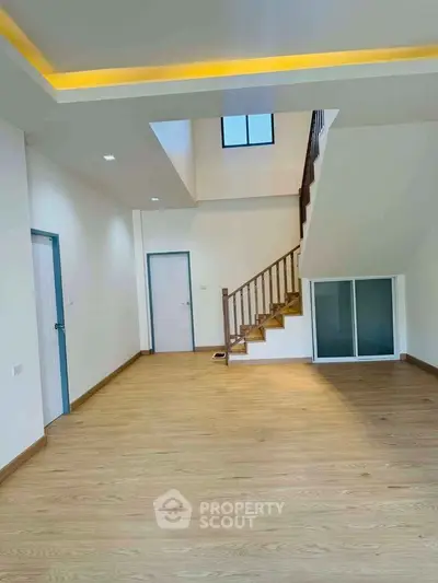 Spacious modern living room with wooden flooring and staircase