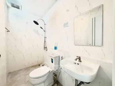 Modern bathroom with sleek fixtures and marble-style tiles