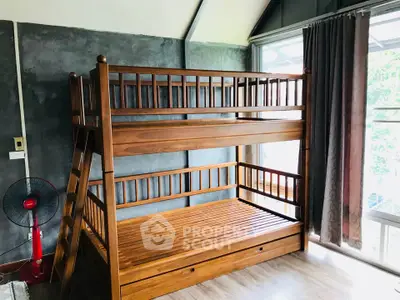 Spacious bedroom with wooden bunk bed and large window for natural light.