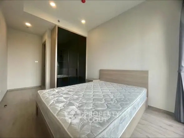 Modern bedroom with minimalist design and large window for natural light.