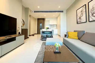 Modern living room with open kitchen, stylish decor, and cozy seating area in a contemporary apartment.