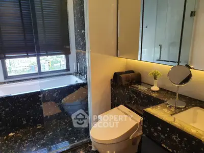 Luxurious bathroom with modern fixtures and city view, featuring elegant black marble accents and sleek design.
