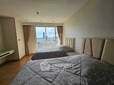 Spacious bedroom with two beds and stunning city view from large window.