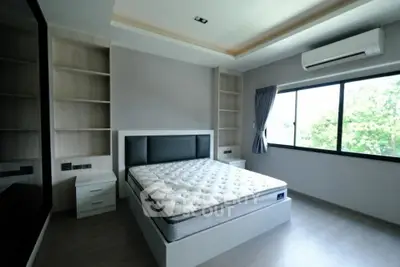 Spacious modern bedroom with large window and built-in shelves