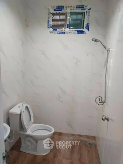 Modern bathroom with marble walls and wooden floor