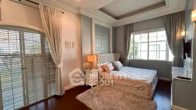 Luxurious bedroom with elegant decor, large window, and plush bedding in a sophisticated home.