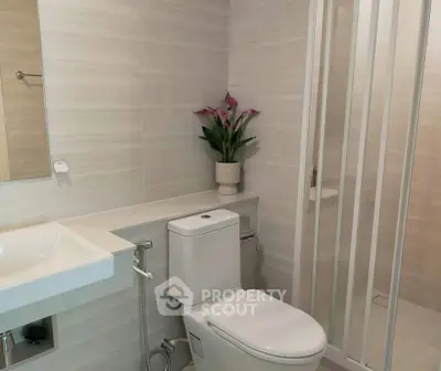 Modern bathroom with sleek design and elegant fixtures, featuring a shower and stylish decor.
