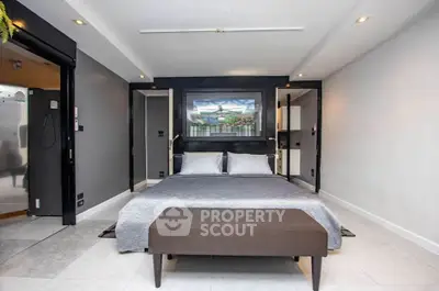 Modern bedroom with sleek design and neutral tones, featuring a comfortable bed and stylish decor.