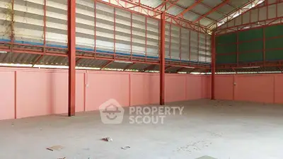 Spacious industrial warehouse with high ceilings and ample natural light, perfect for storage or manufacturing.