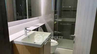 Modern bathroom with sleek design, featuring a glass shower and stylish vanity.
