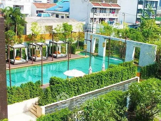 Luxurious outdoor pool area with cabanas and lush greenery in a modern residential complex.
