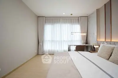Elegant bedroom with modern decor and large window for natural light.