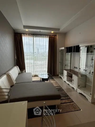 Modern living room with large windows and stylish furniture in a high-rise apartment.