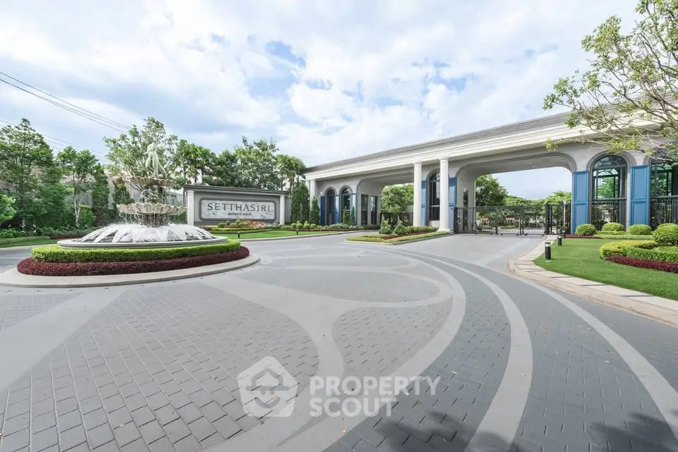 Luxurious entrance of a high-end residential estate with elegant landscaping and grand architecture.