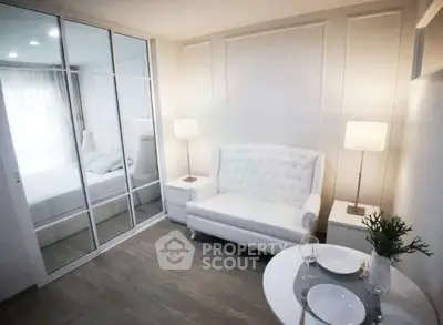 Chic modern living room with elegant white sofa and mirrored wardrobe in stylish apartment.