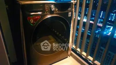 Modern washing machine on high-rise balcony with city night view