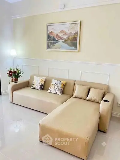 Elegant living room with modern beige sectional sofa and stylish wall art, perfect for cozy relaxation.