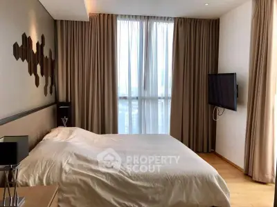Modern bedroom with stylish decor and natural light in a high-rise apartment.