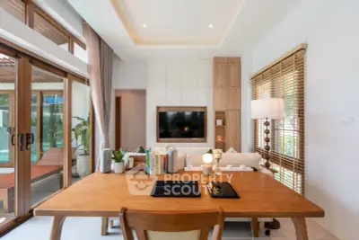 Modern living room with stylish decor and pool view, featuring wooden accents and natural light.