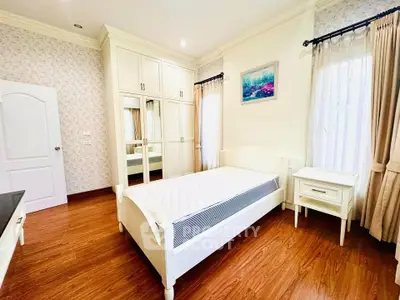 Charming bedroom with elegant white furniture and natural light, perfect for a cozy retreat.