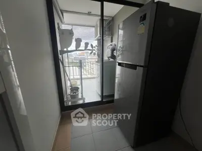 Modern kitchen with sleek fridge and balcony view, perfect for urban living.