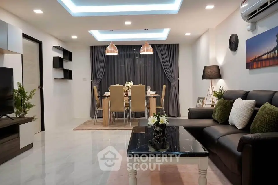 Modern living room with elegant dining area, stylish lighting, and cozy seating in a contemporary apartment.