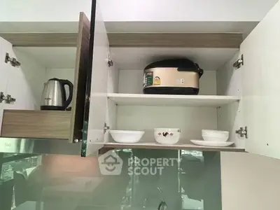 Modern kitchen cabinet with appliances and dishes, showcasing sleek storage solutions.