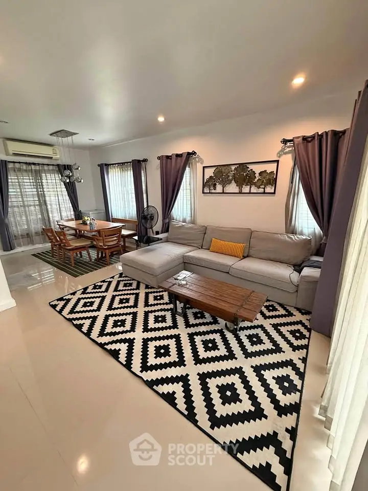 Spacious living room with modern decor and dining area, featuring elegant curtains and stylish furniture.