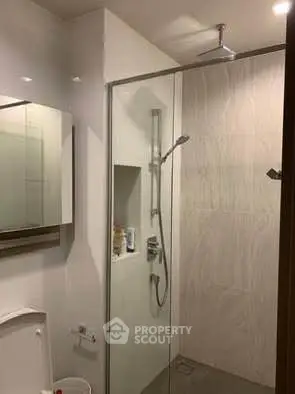 Modern bathroom with glass shower enclosure and sleek fixtures.
