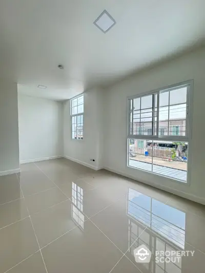 Bright and spacious empty room with large windows and glossy tiled floor