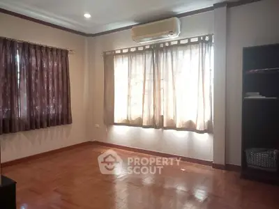 Spacious living room with wooden flooring and large windows for natural light