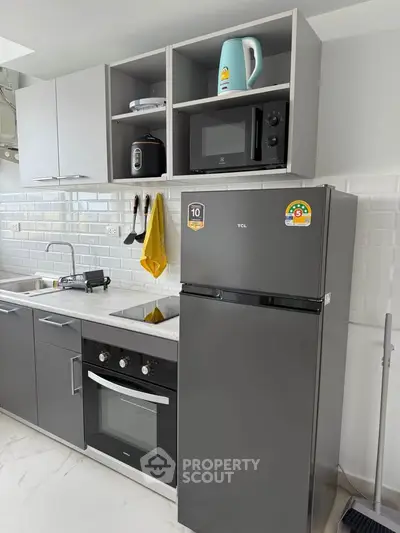 Modern kitchen with sleek appliances and stylish cabinetry in a contemporary apartment.