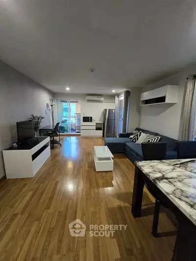 Spacious modern living room with wooden flooring and stylish furniture