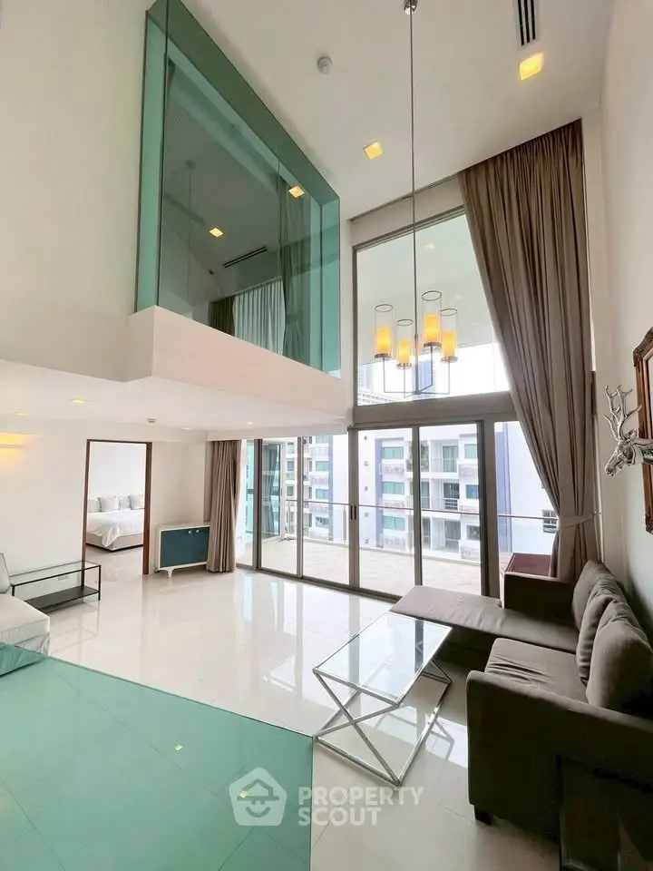 Luxurious modern living room with high ceilings and floor-to-ceiling windows offering stunning views.