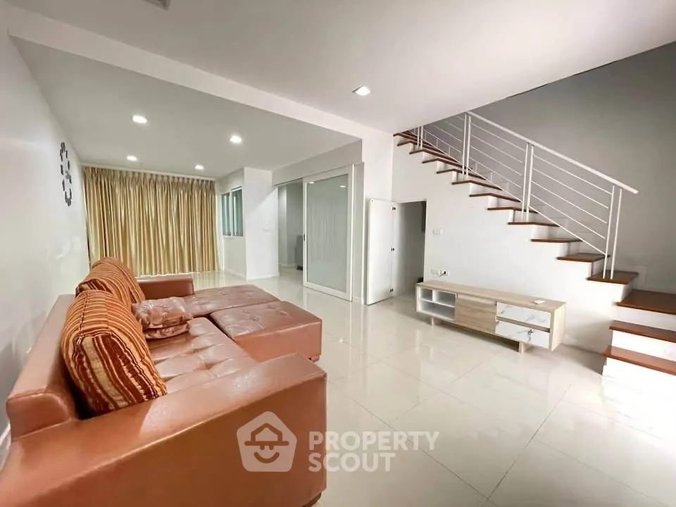 Spacious modern living room with sleek staircase and cozy sectional sofa